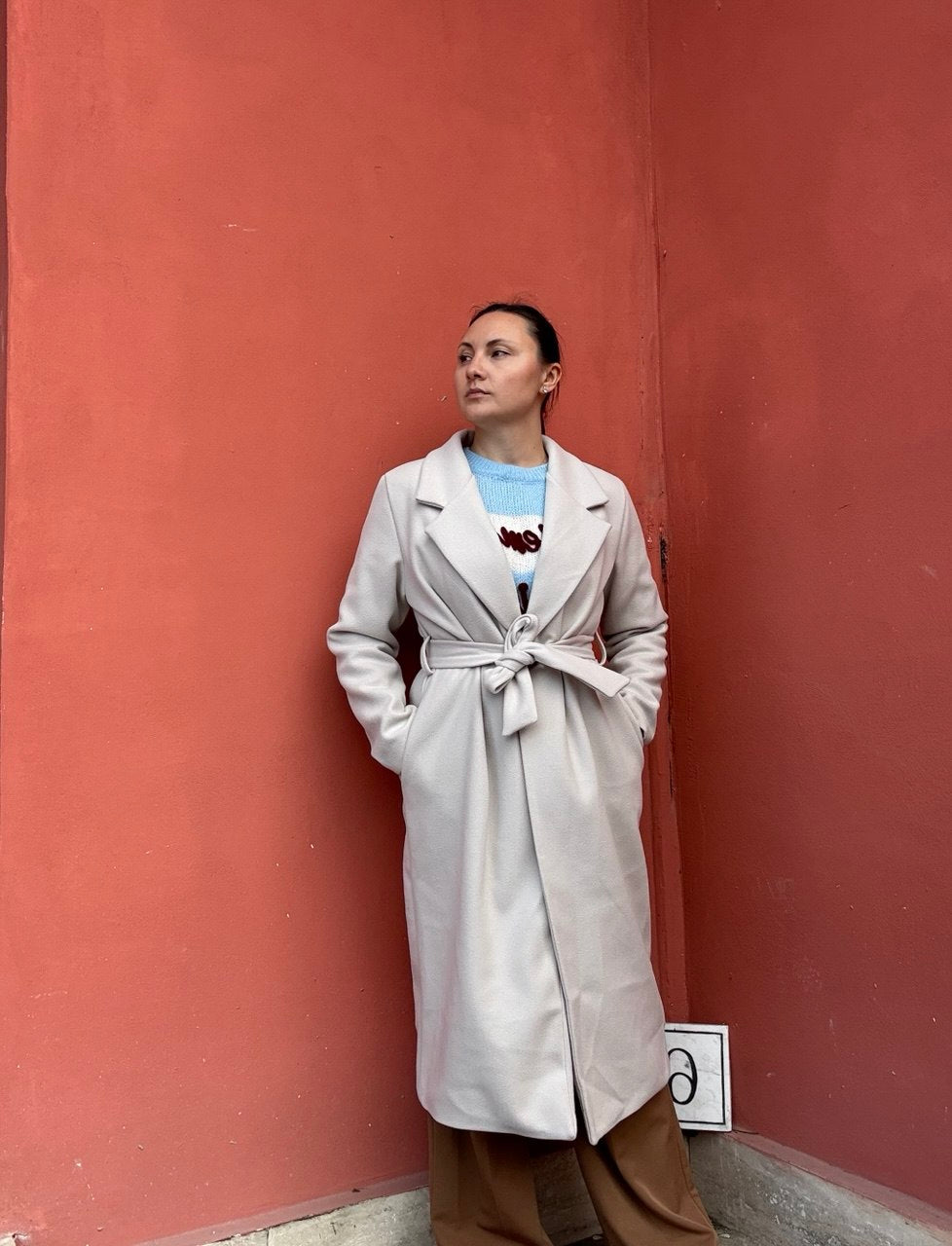 Cappotto lungo panna con cintura indossato vista frontale